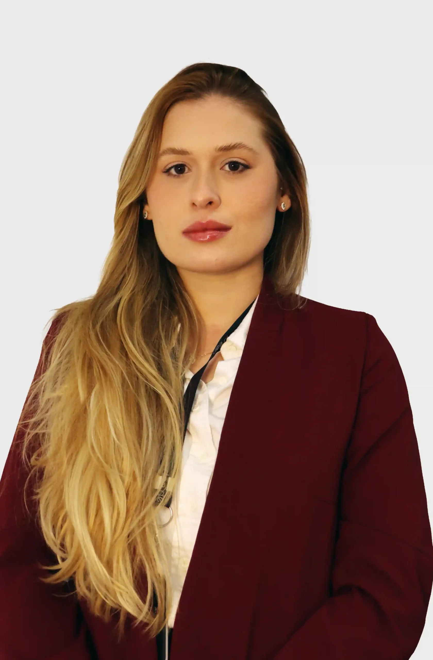 Integrante do escritório de blazer bordô e camisa branca, com cabelos longos claros