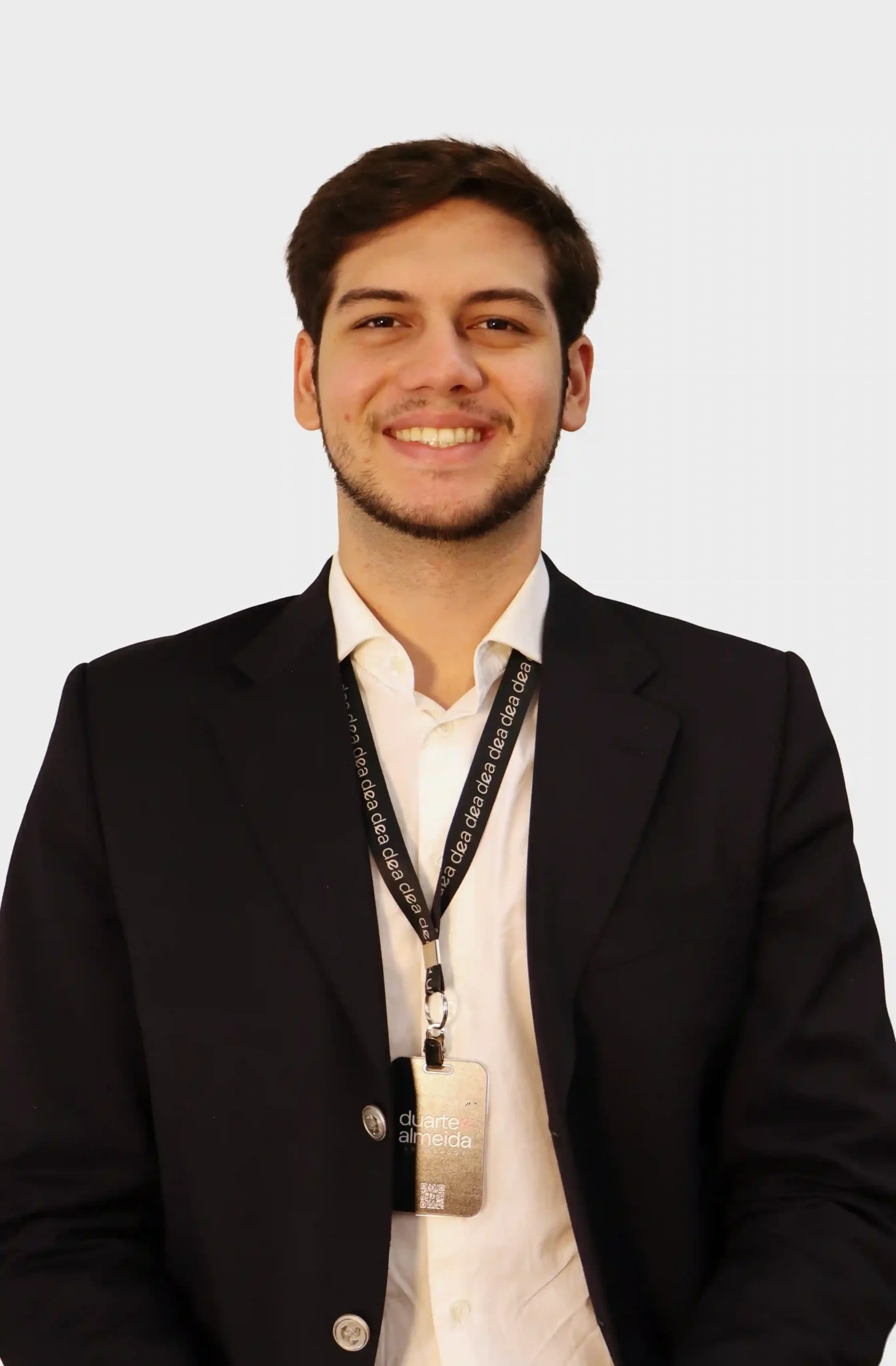 Integrante do escritório de blazer preto e camisa branca, sorrindo, com crachá dourado