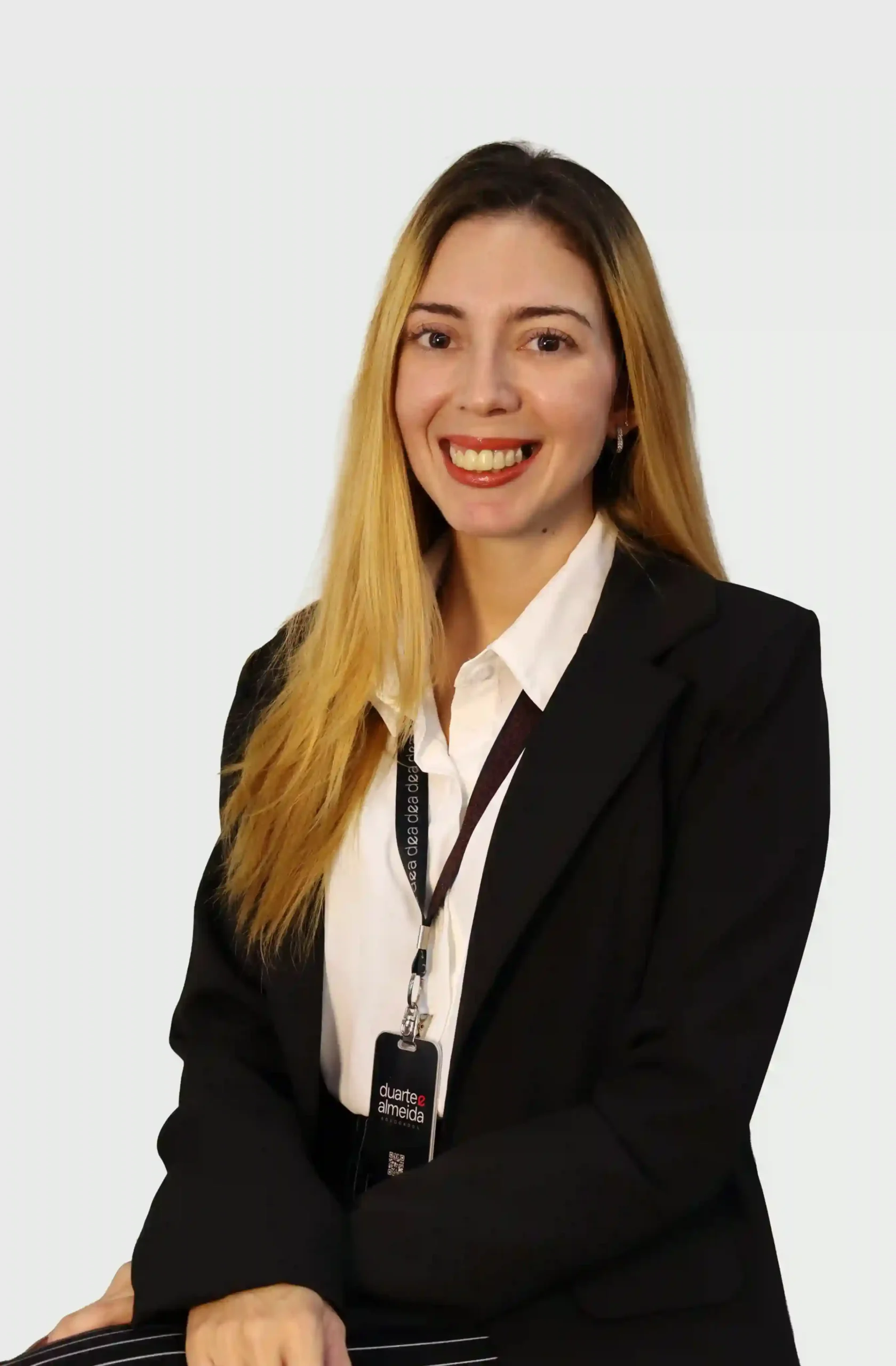 Integrante do escritório de blazer preto e camisa branca, sorrindo, com crachá