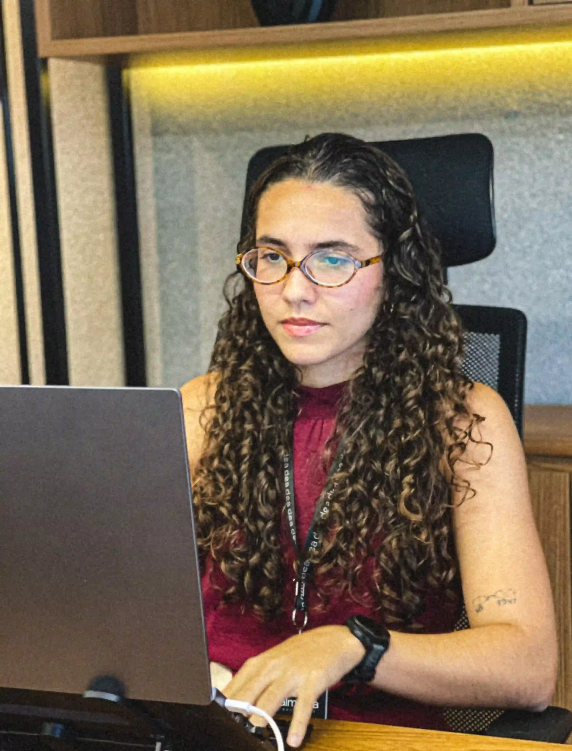 Advogada do escritório de óculos analisando um caso no notebook