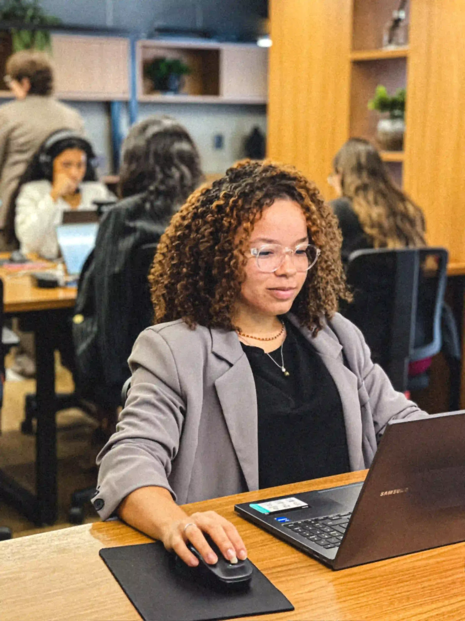 Advogada do escritório de blazer cinza analisando processo no notebook