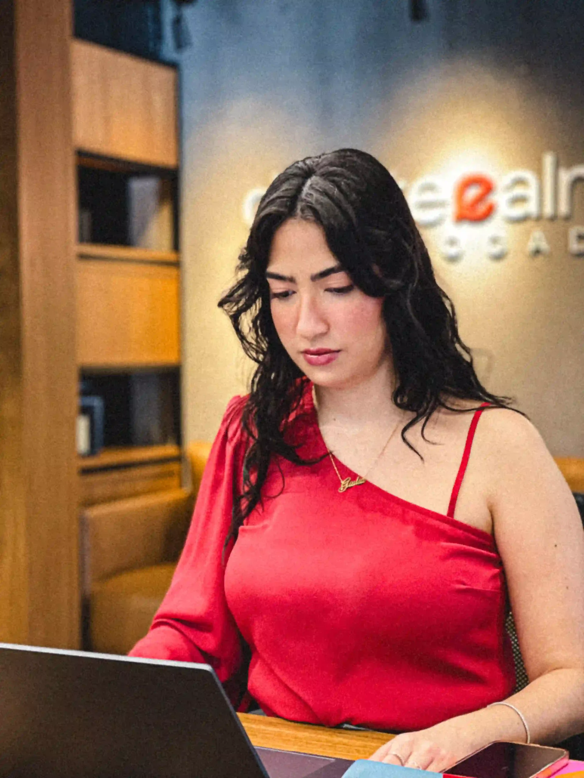 Integrante do Duarte e Almeida Advogados de blusa vermelha em atendimento ao notebook