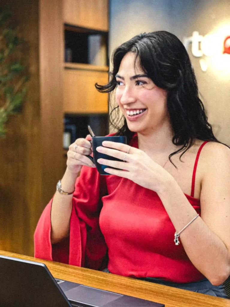 Integrante do Duarte e Almeida Advogados sorrindo com uma caneca durante pausa no escritório