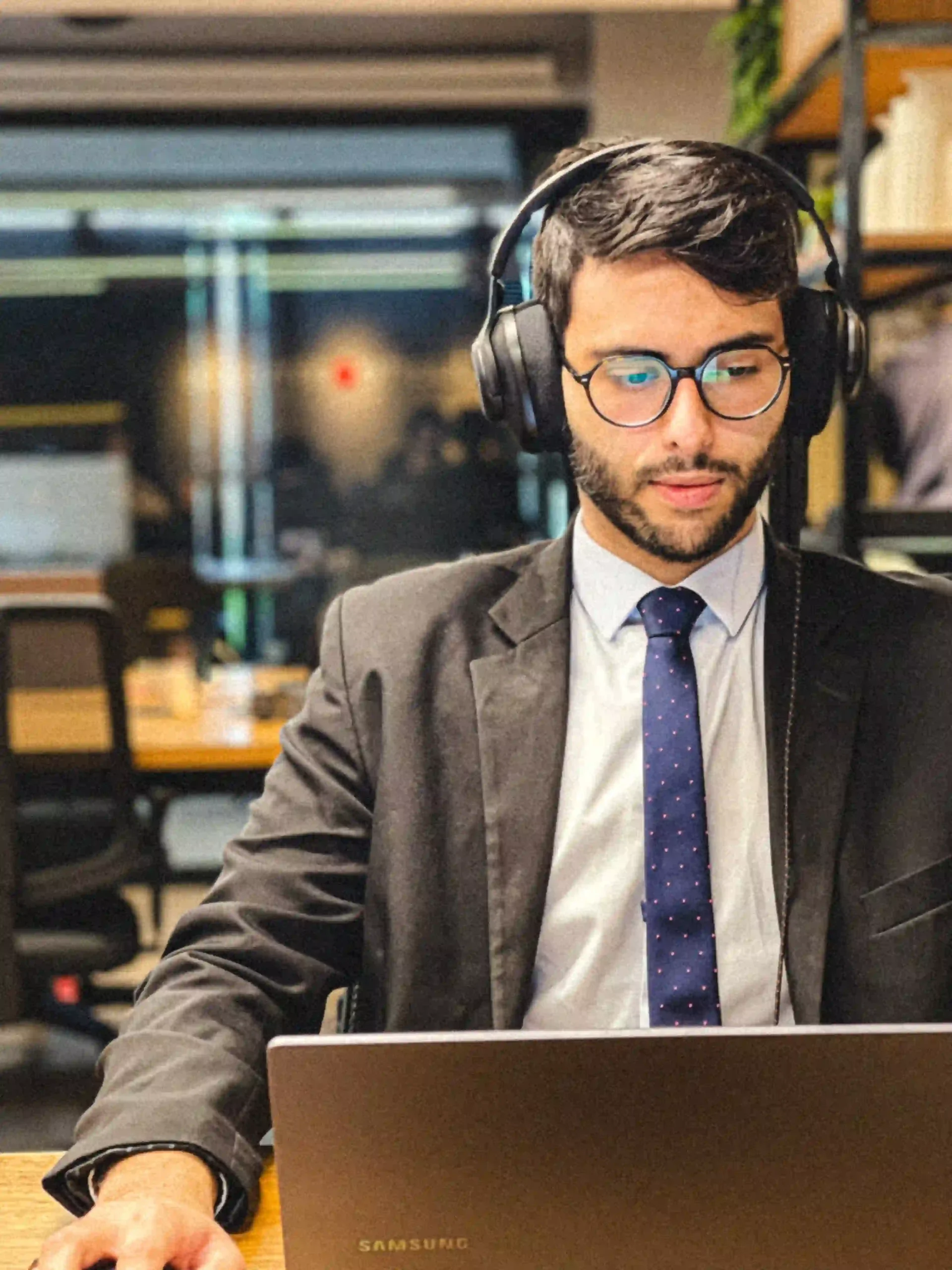 Rian Fernandes, advogado do Duarte e Almeida Advogados, de headset em atendimento ao notebook