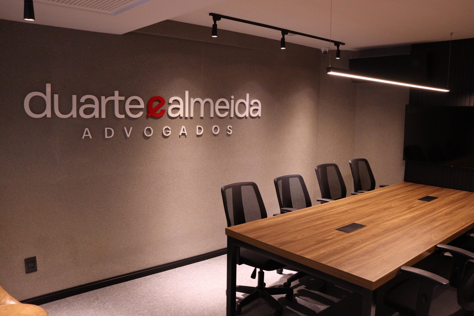 Sala de reunião do Duarte e Almeida Advogados com a marca aplicada em relevo na parede